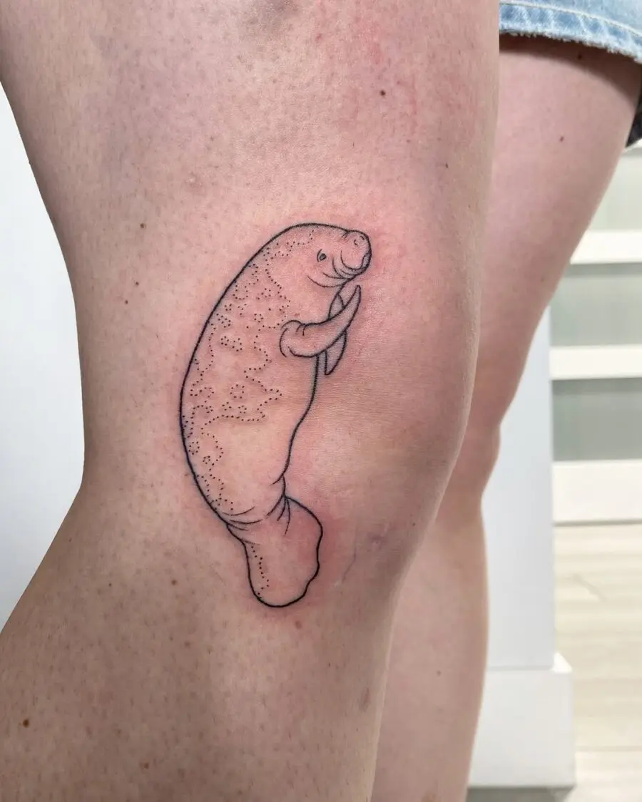 Charming and playful manatee thigh tattoo design