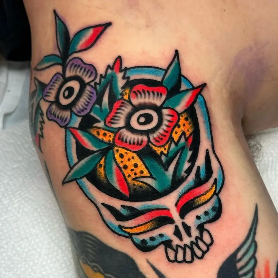 Vibrant dead flower skull tattoo with leaves
