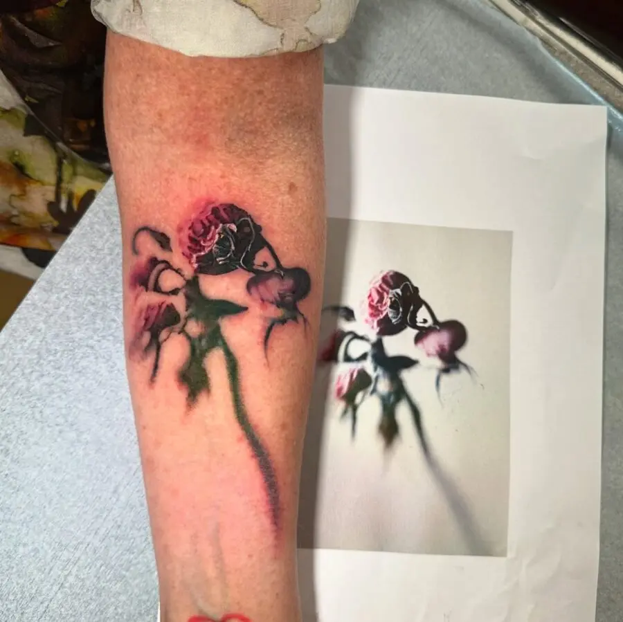 Elegantly decayed floral tattoo on the arm