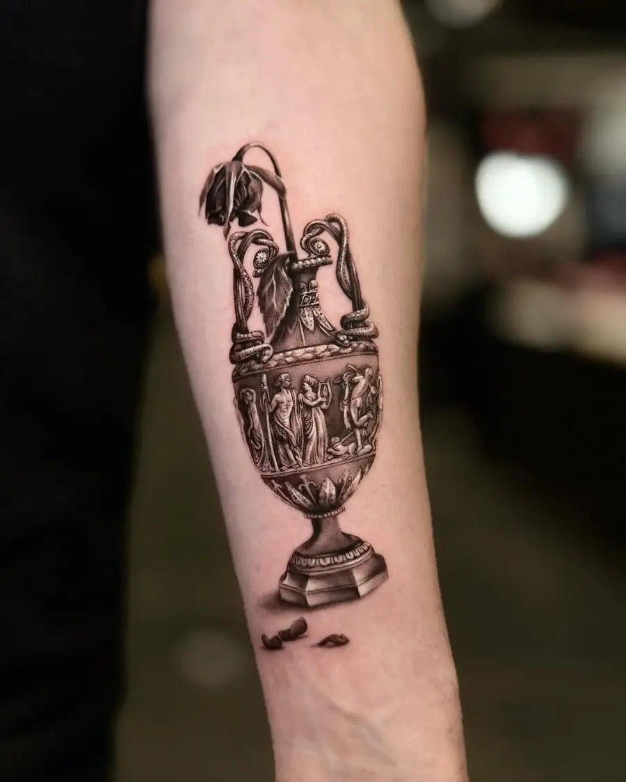 Intricate vase tattoo with a wilted flower