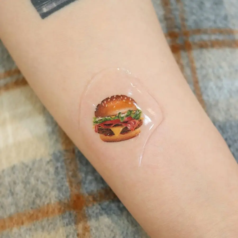 Vibrant hamburger tattoo with playful elements