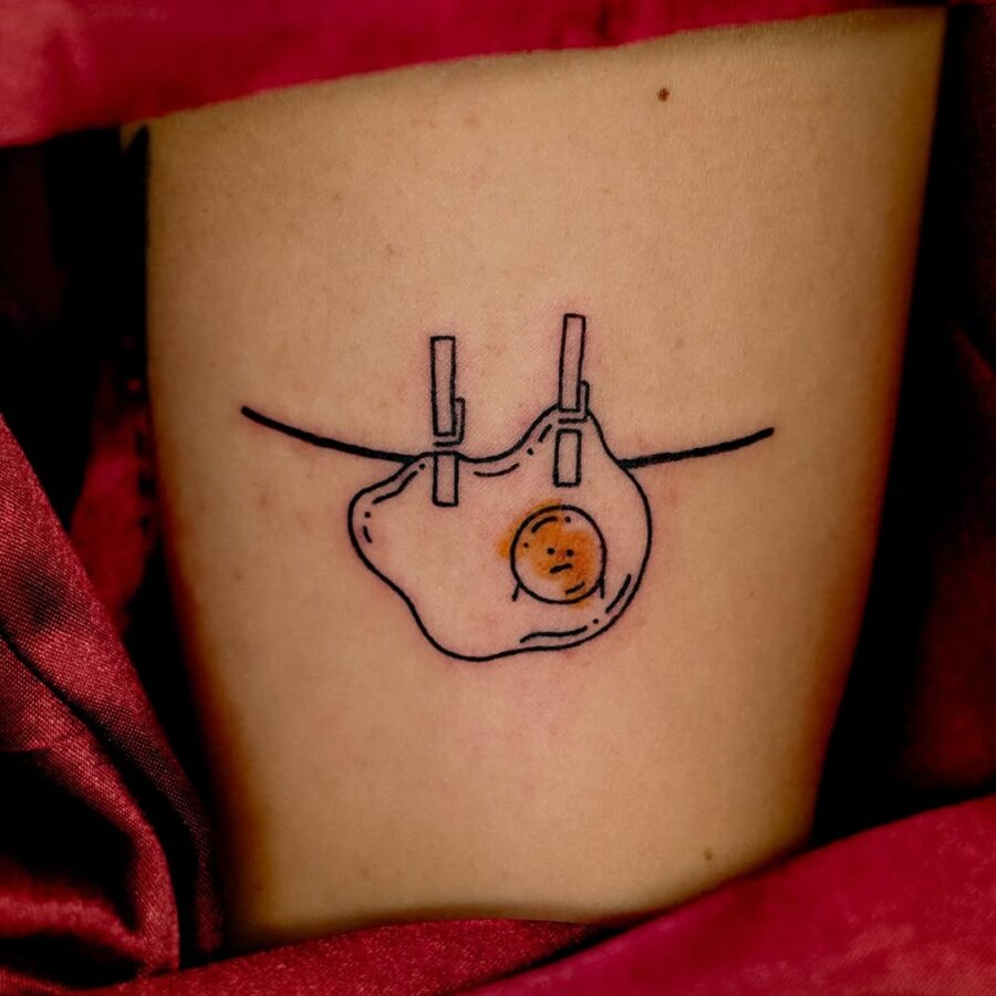 Unique Egg Tattoo with Clothesline Design