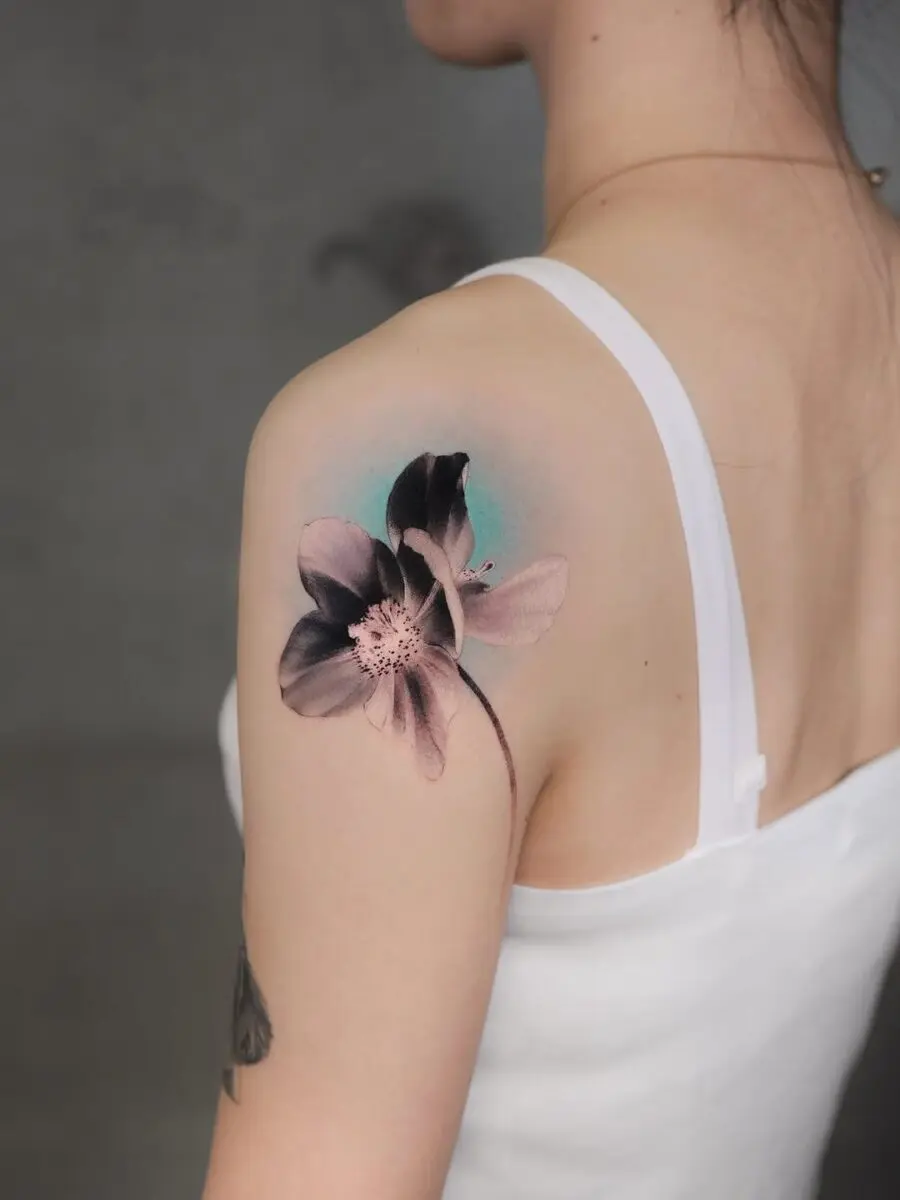 Delicate flower tattoo on shoulder