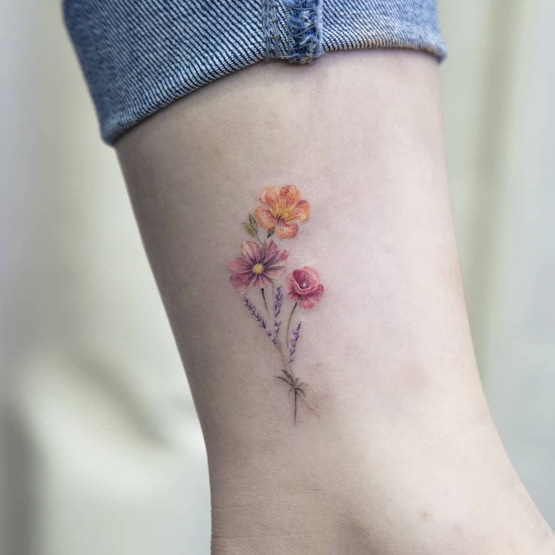 Delicate floral accents for ankle tattoos