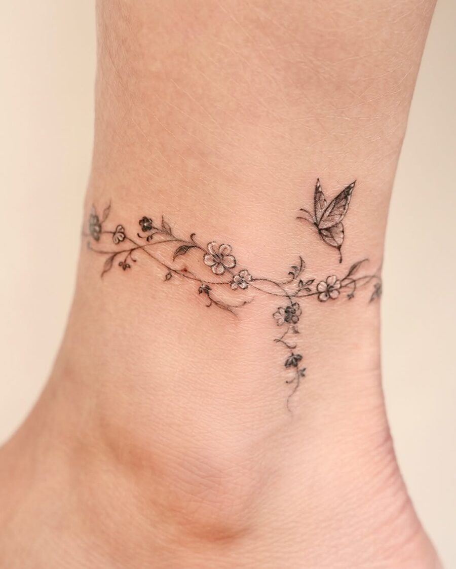 Delicate floral ankle tattoo with butterfly accents