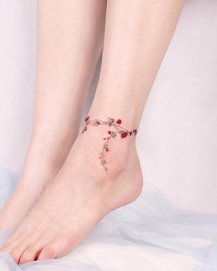 Delicate floral ankle tattoo design with grace
