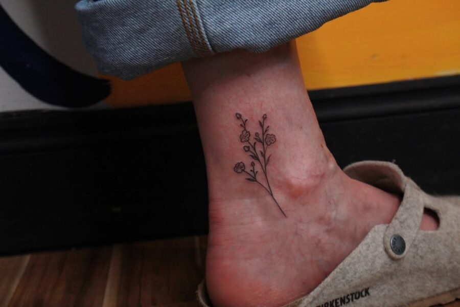 Elegant minimalistic flower ankle tattoo design