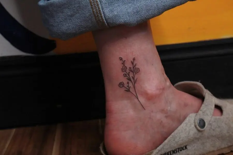 Elegant minimalistic flower ankle tattoo design