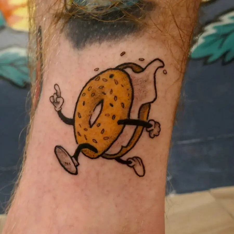 A whimsical tattoo featuring a playful bagel