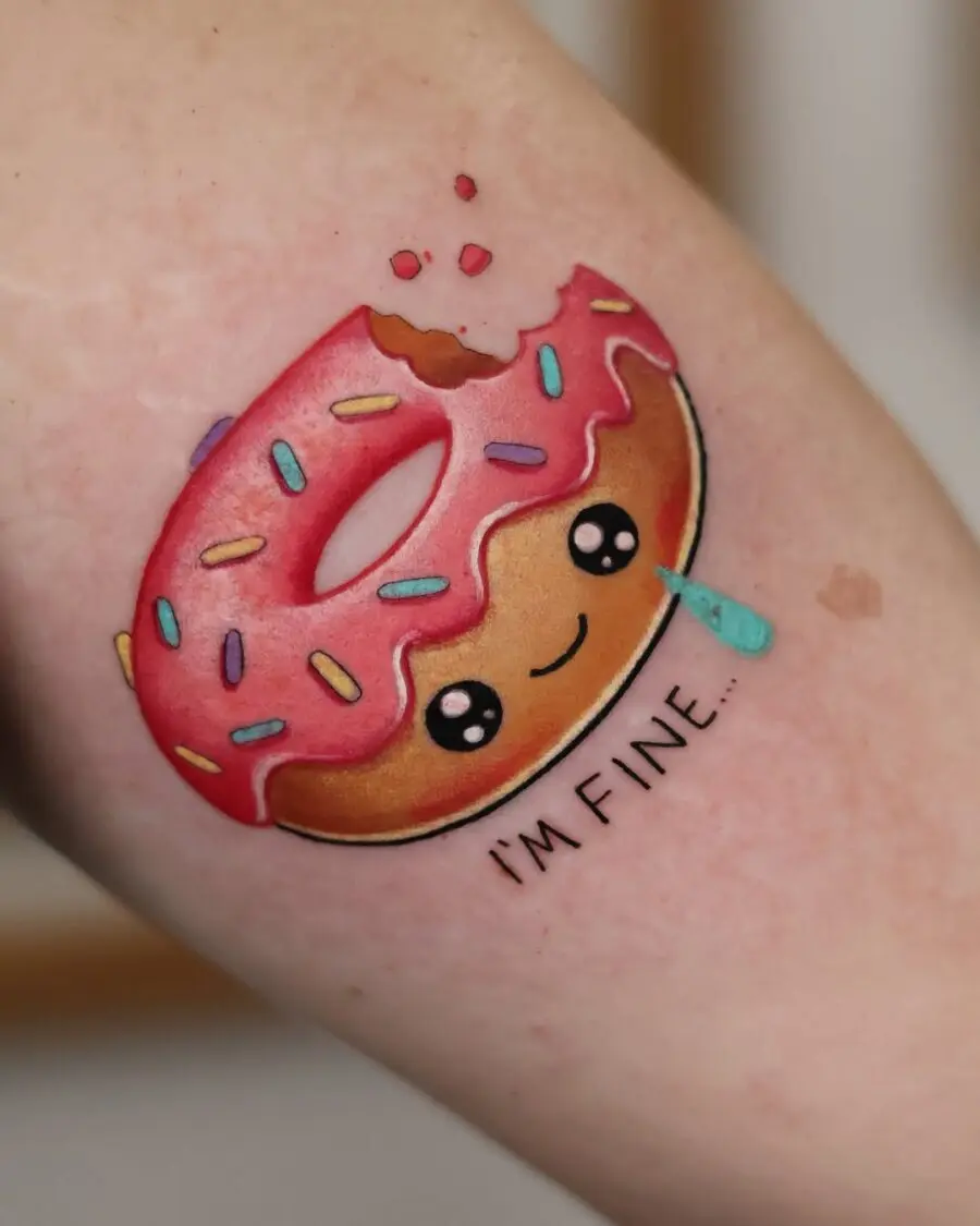 Humorous donut tattoo with a cheeky expression