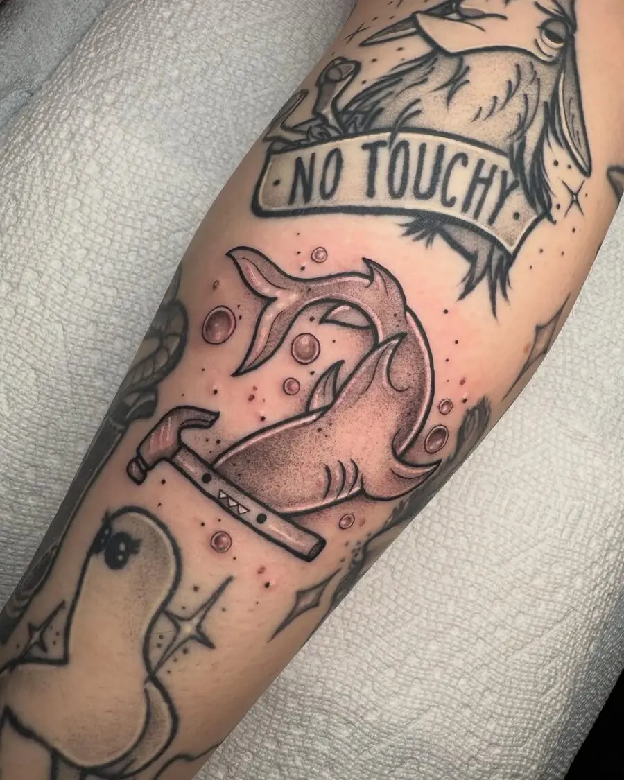 Whimsical shark tattoo with a hammer twist