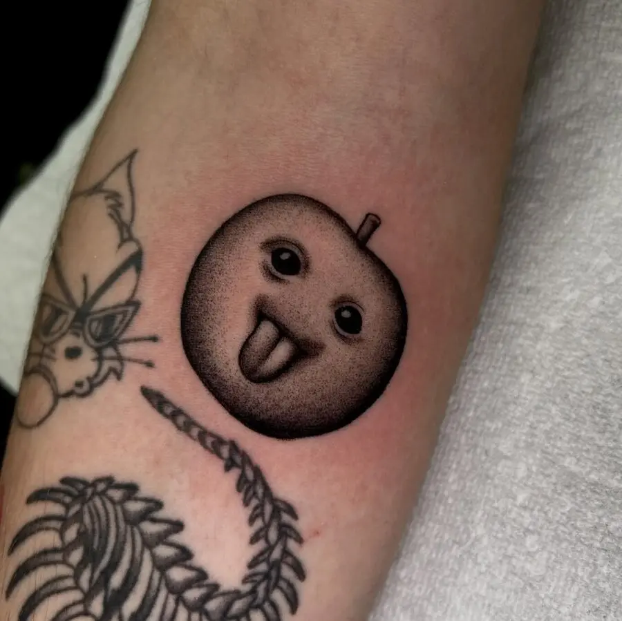 Quirky apple emoji tattoo with a playful vibe