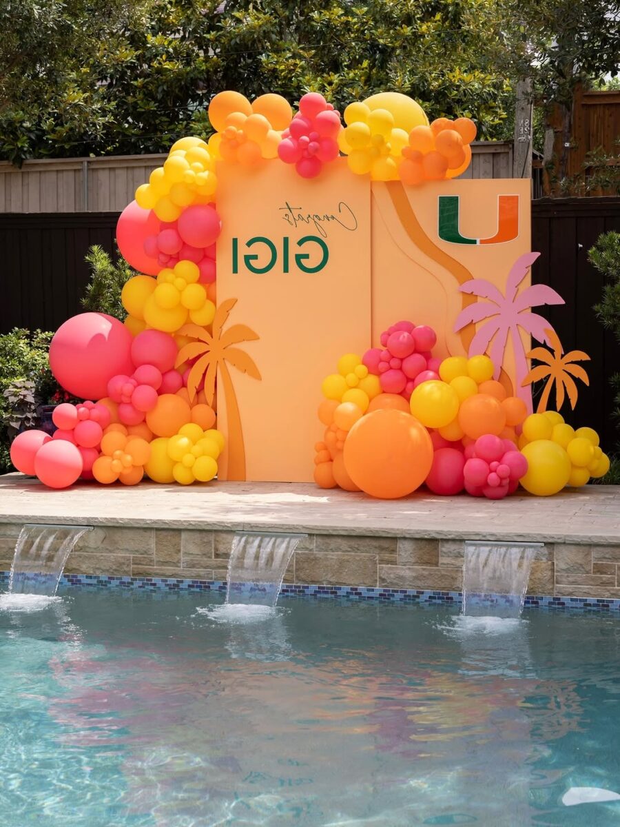 Vibrant poolside balloon arch decor for graduation