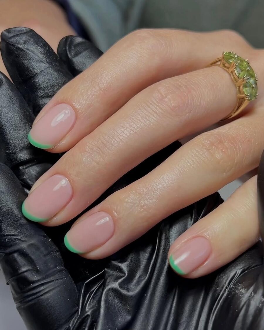 Stylish green French tip nails with a twist