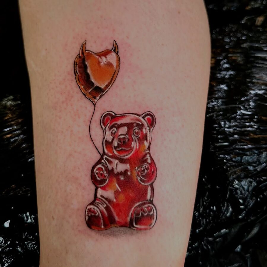 Whimsical gummy bear tattoo with a balloon