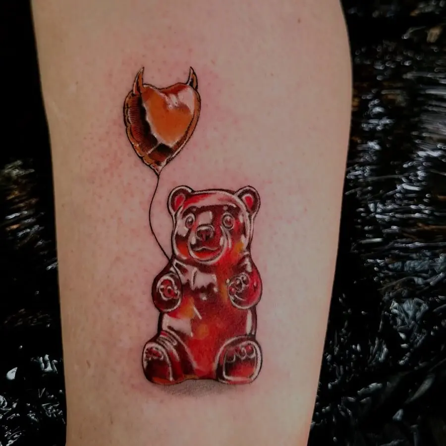 Whimsical gummy bear tattoo with a balloon