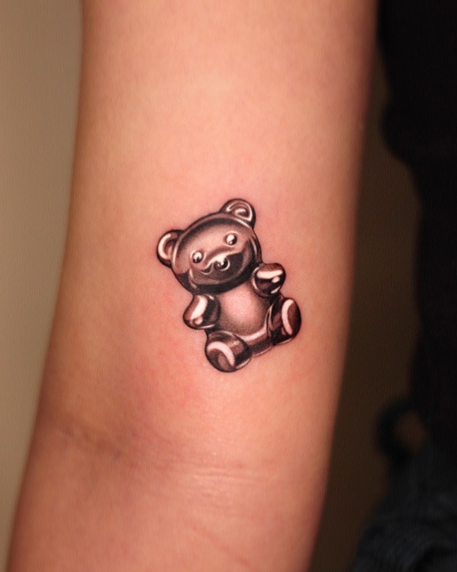 Realistic gummy bear tattoo on forearm