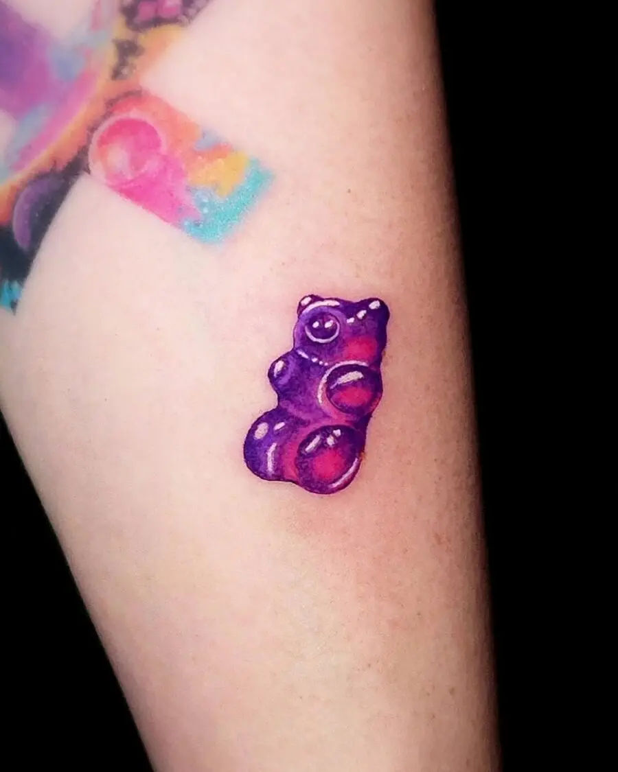 Vivid purple gummy bear tattoo on arm