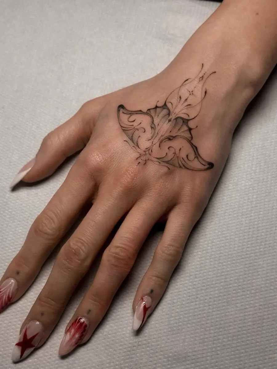 Intricate floral hand tattoo with elegant details