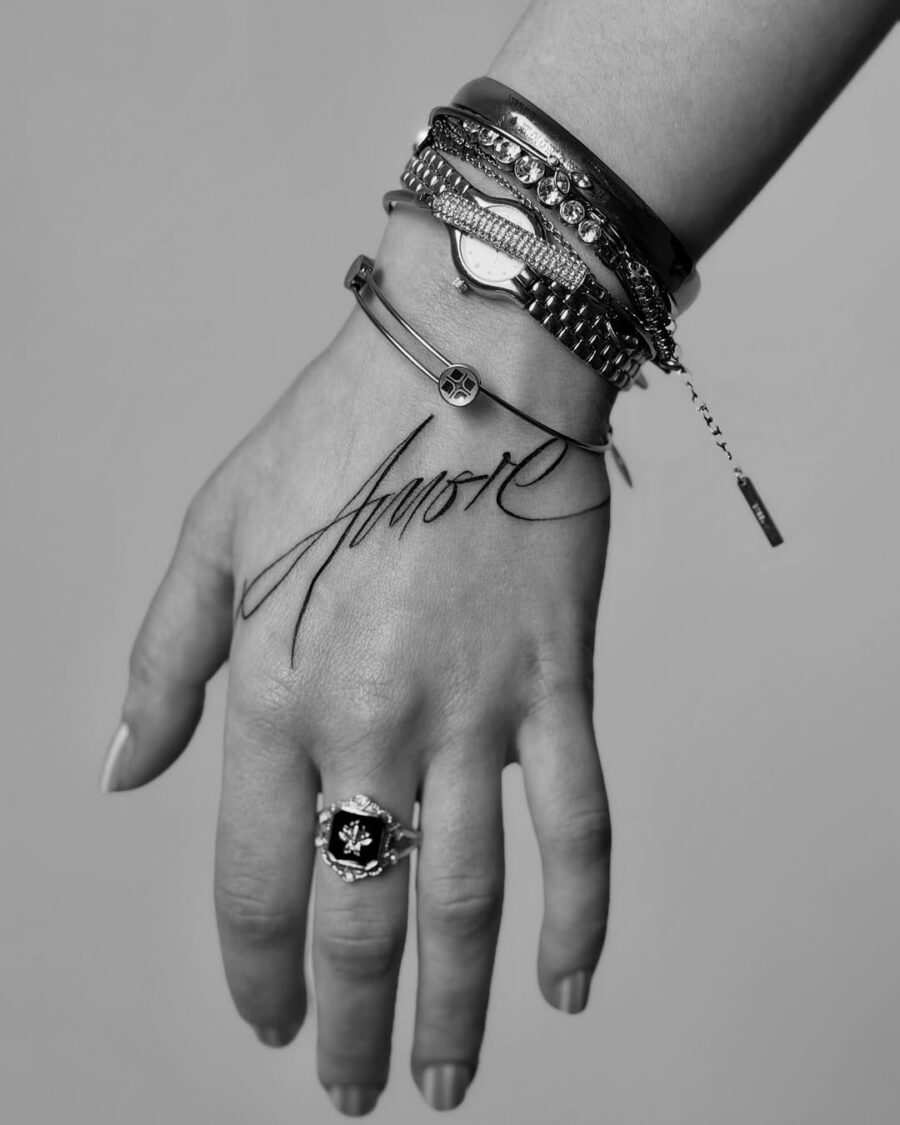 Elegant script tattoo with stylish accessories