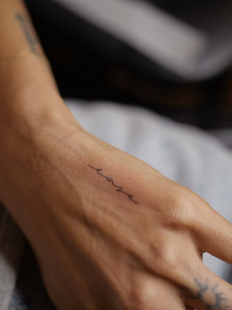Delicate Handwriting Tattoo of the Word 'Ease'