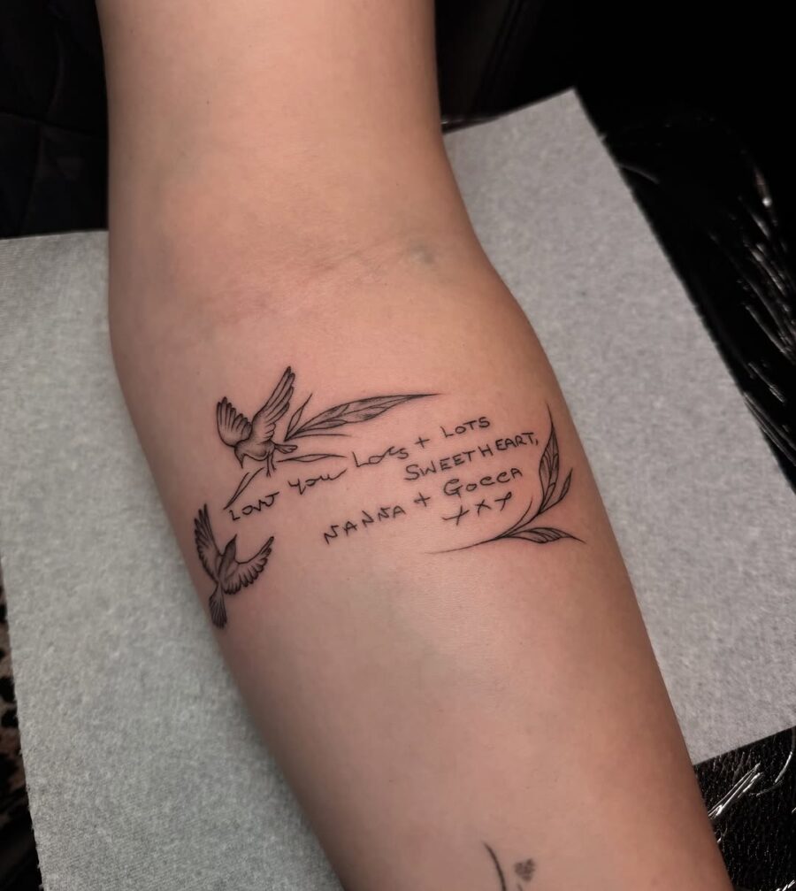 Elegantly scripted tattoo with bird motifs