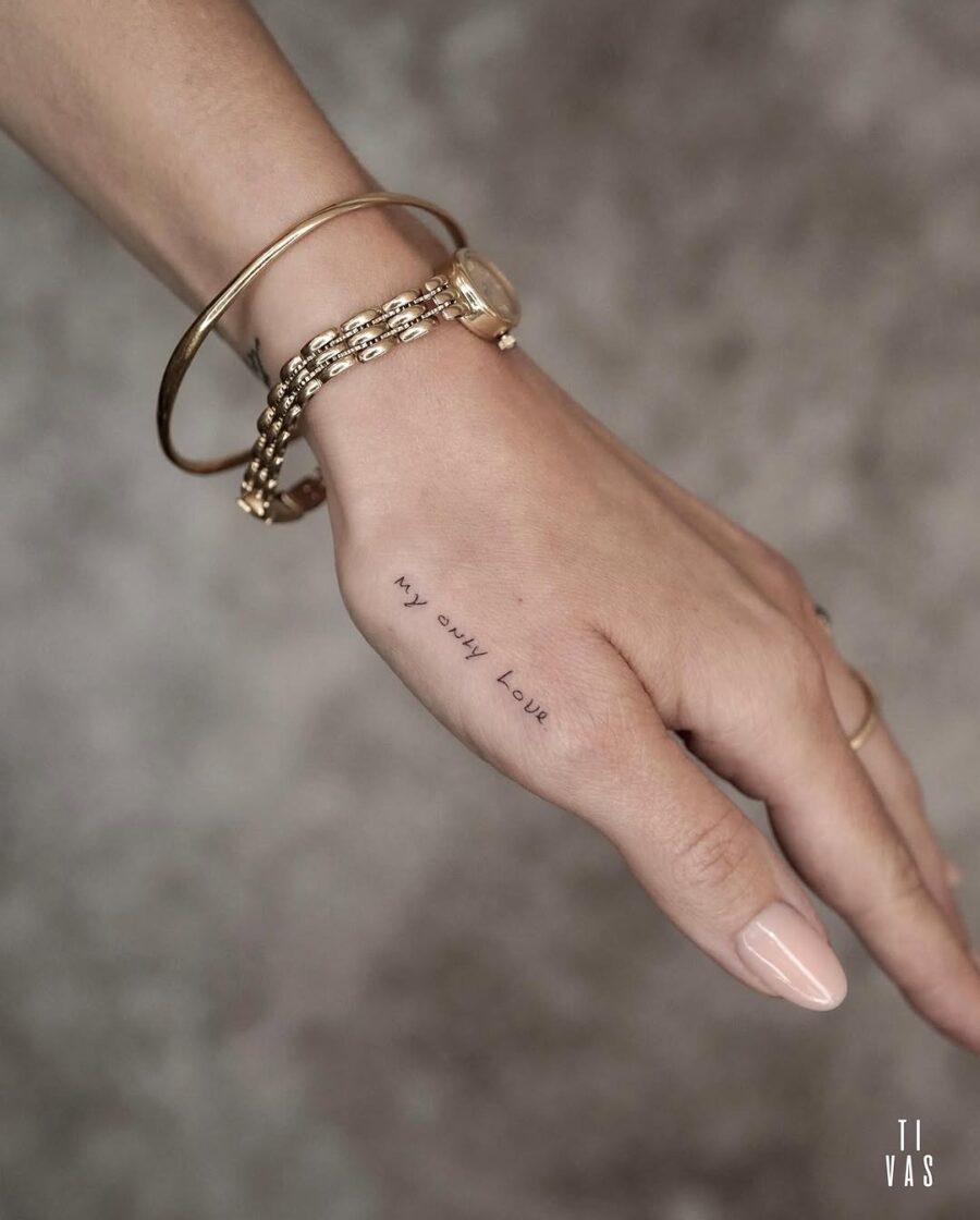 Elegant handwritten tattoo on a hand
