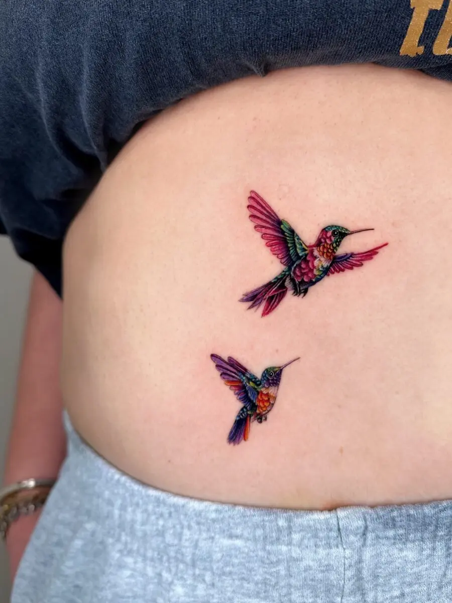 Colorful hummingbirds gracefully inked on skin