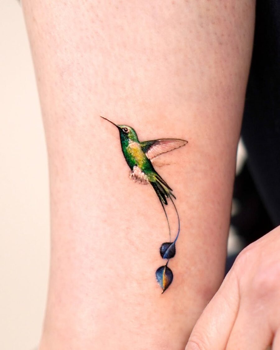 Elegant hummingbird tattoo with floral accents