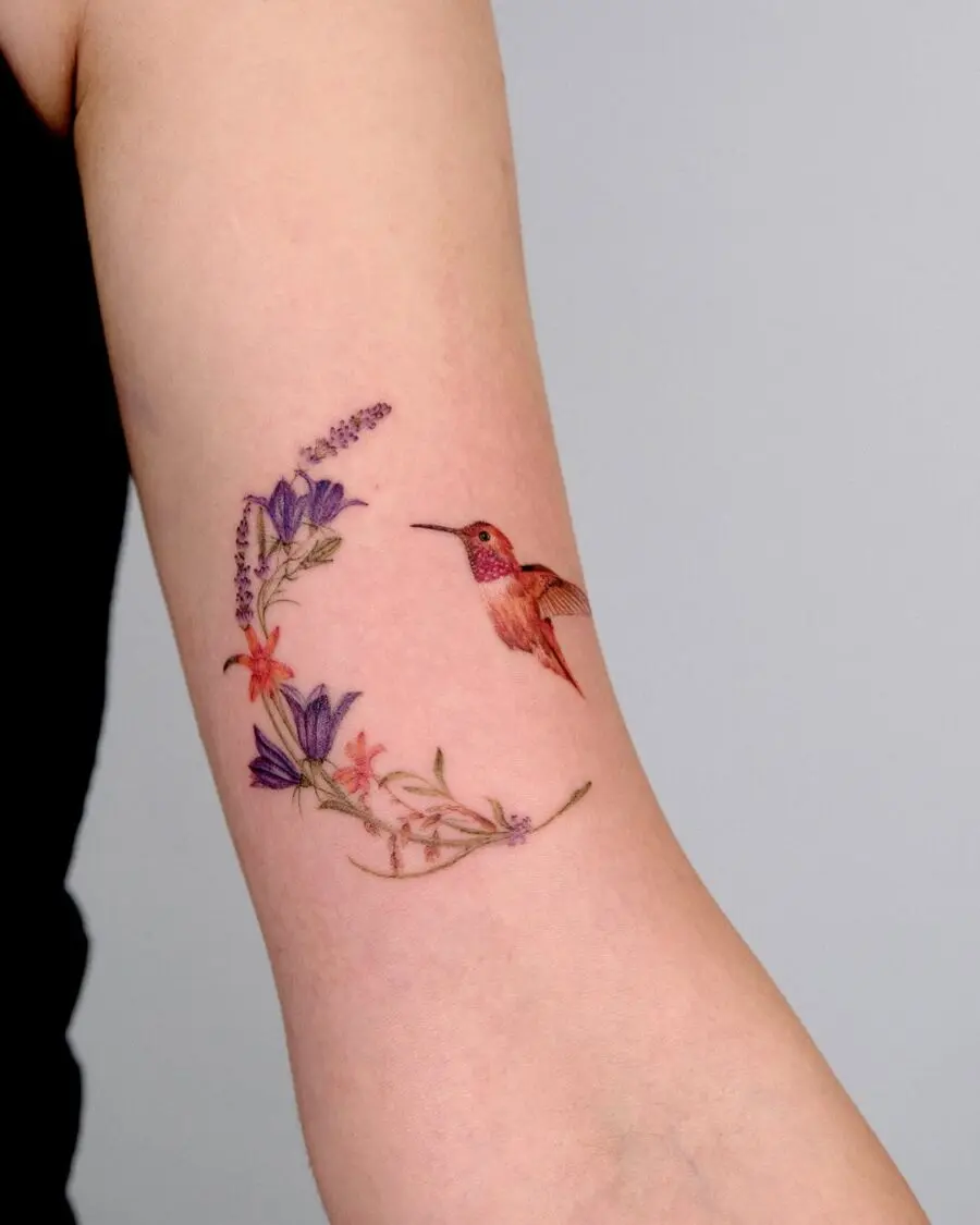Vibrant hummingbird tattoo with floral accents