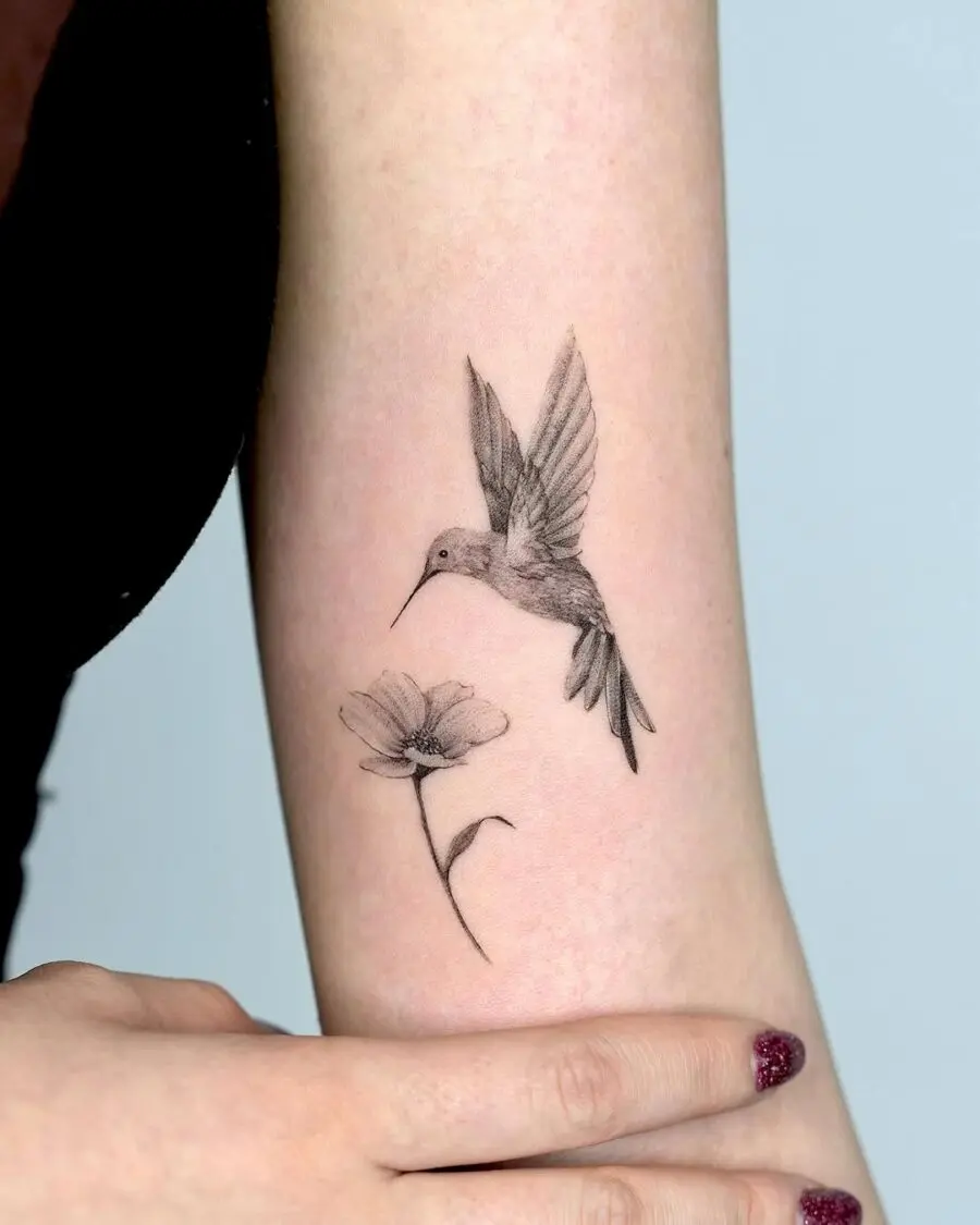 Delicate hummingbird tattoo in black and gray