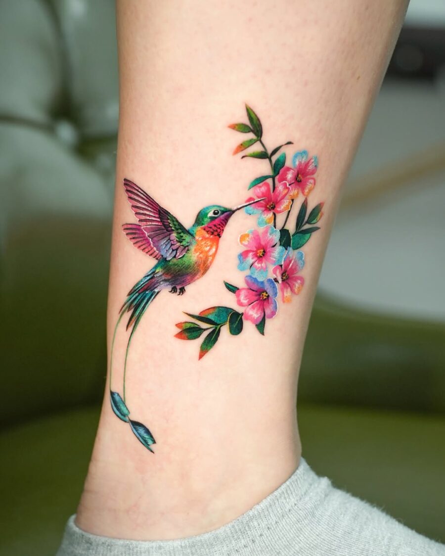 Vibrant hummingbird tattoo with floral accents