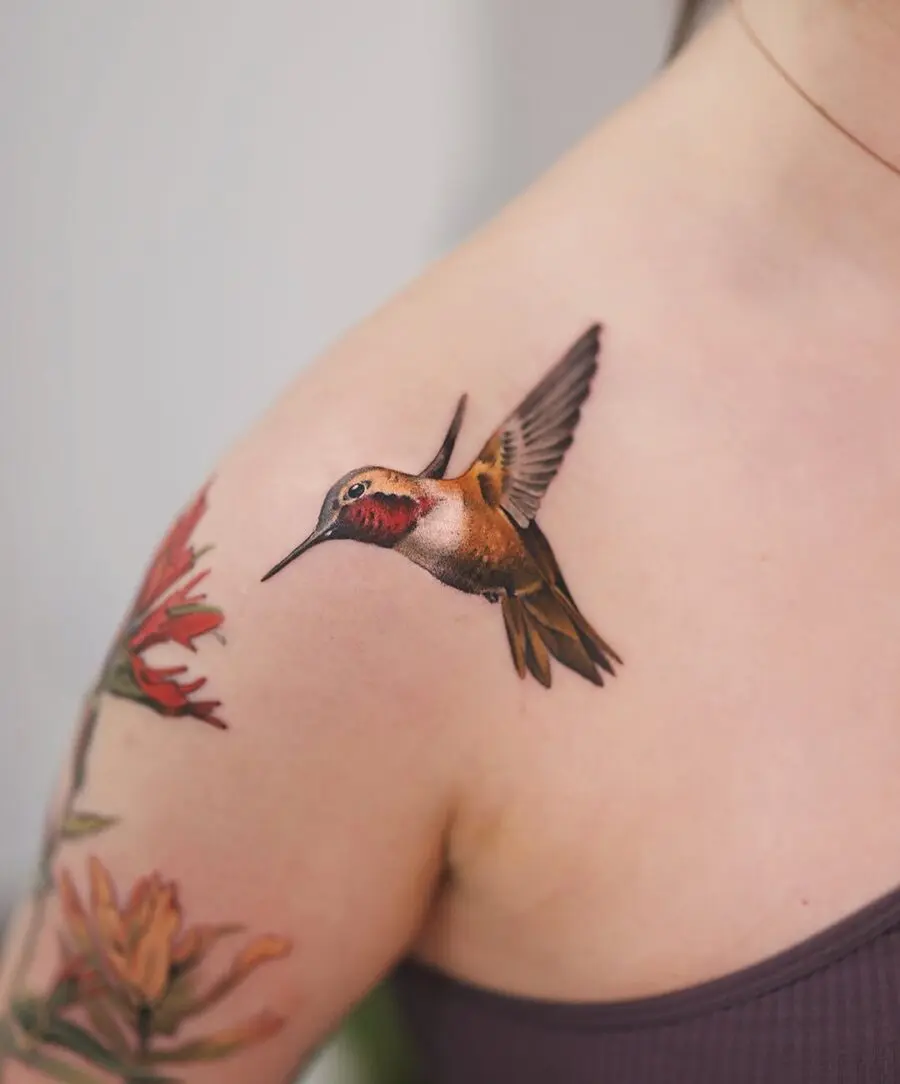 Vibrant hummingbird tattoo with floral accents