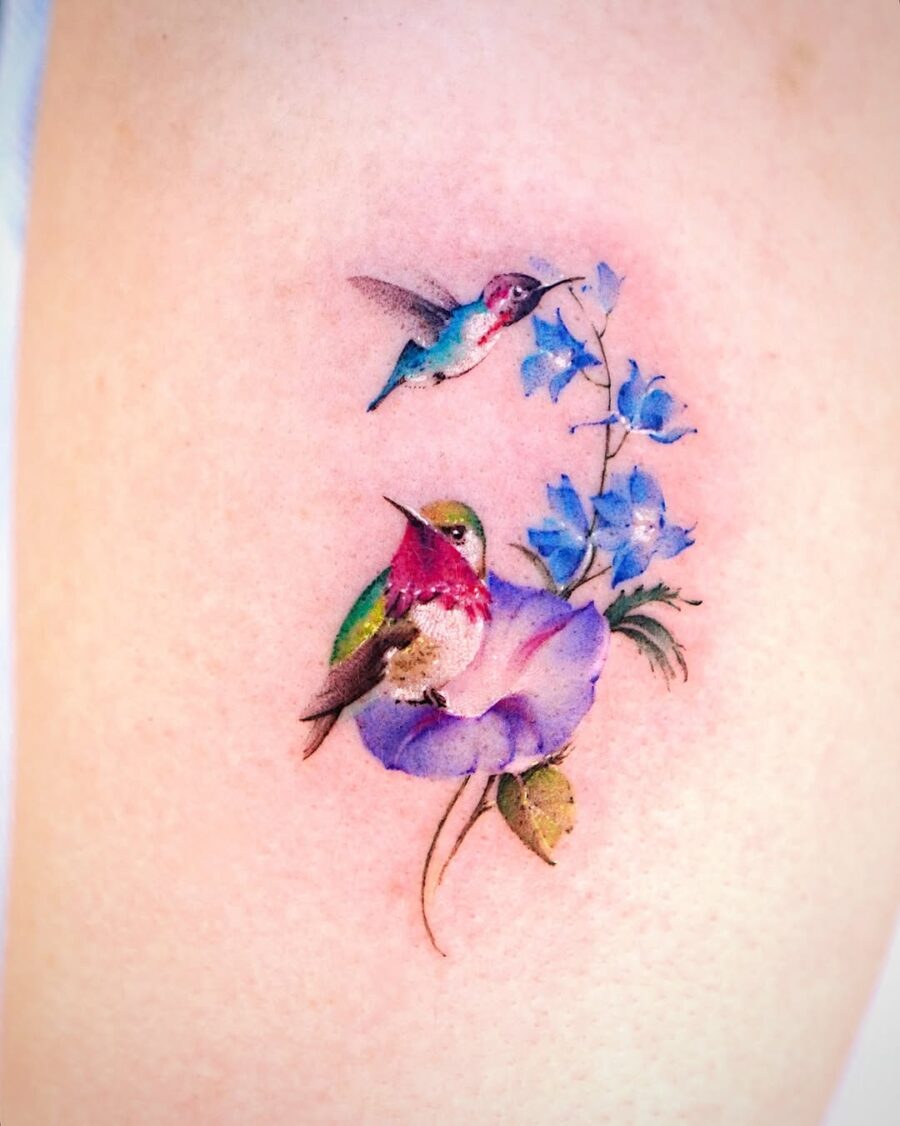 Colorful hummingbird tattoo with vibrant floral elements
