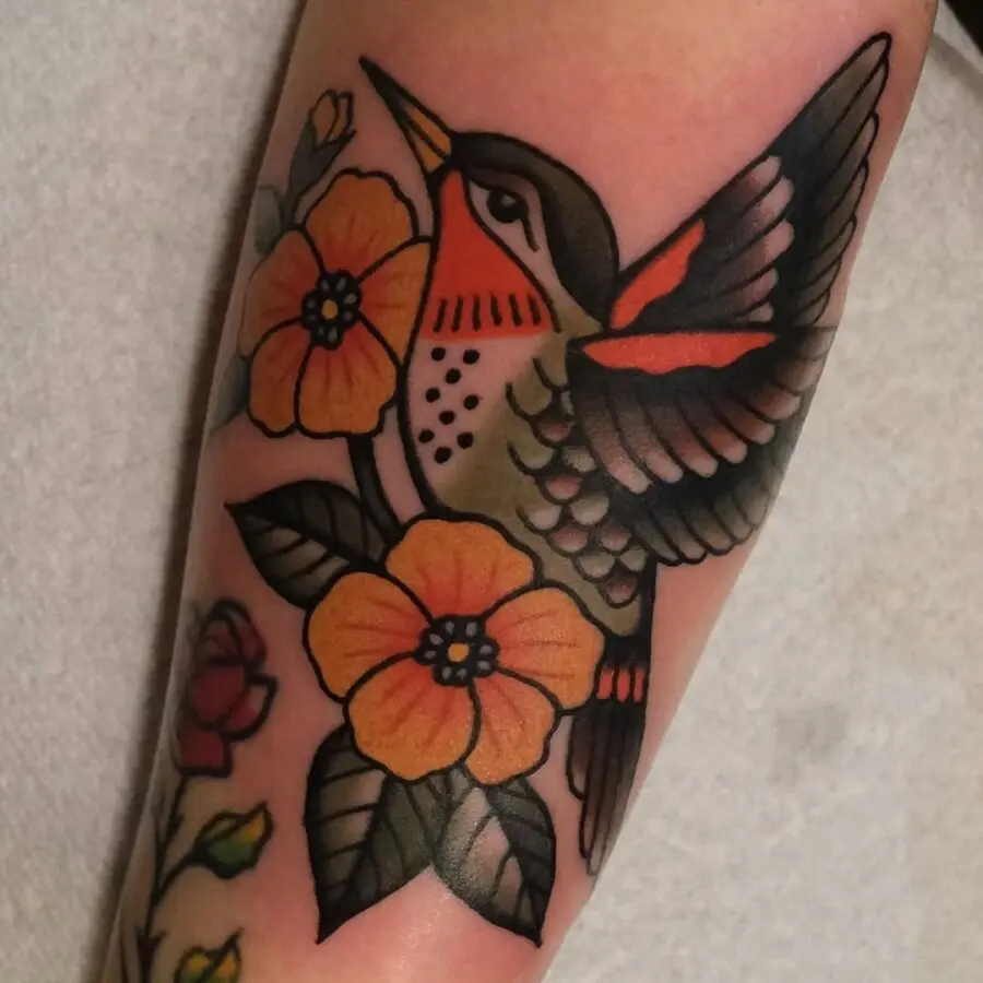 Vibrant hummingbird tattoo with floral elements