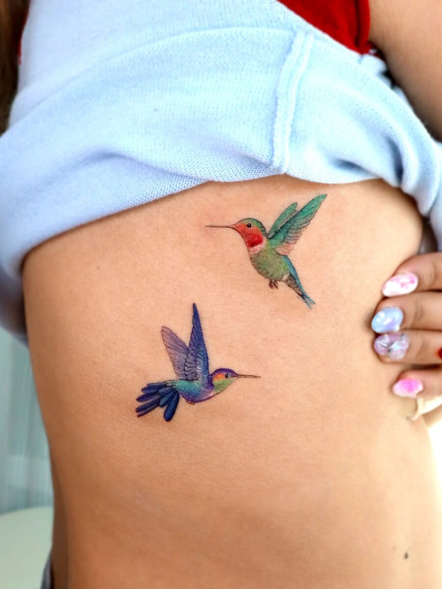 Colorful hummingbirds in delicate tattoo style