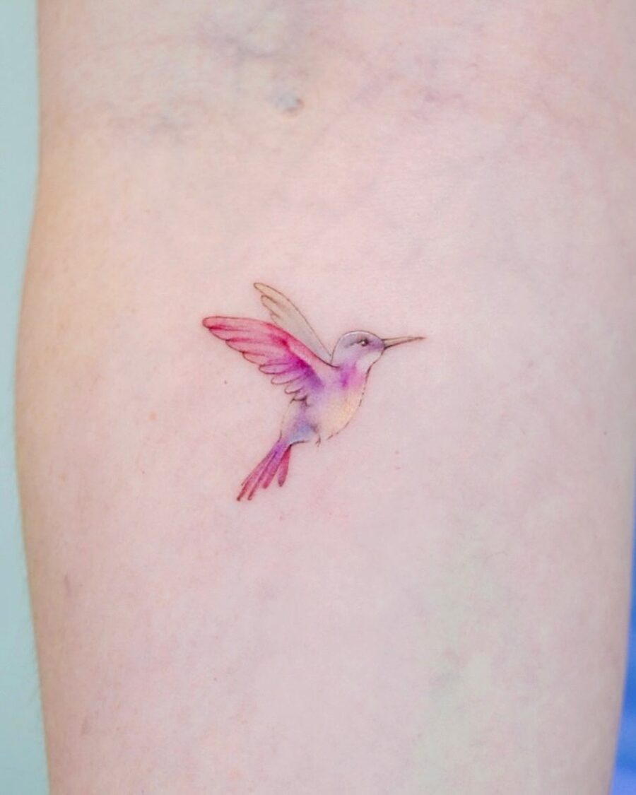 Delicate watercolor hummingbird tattoo on skin
