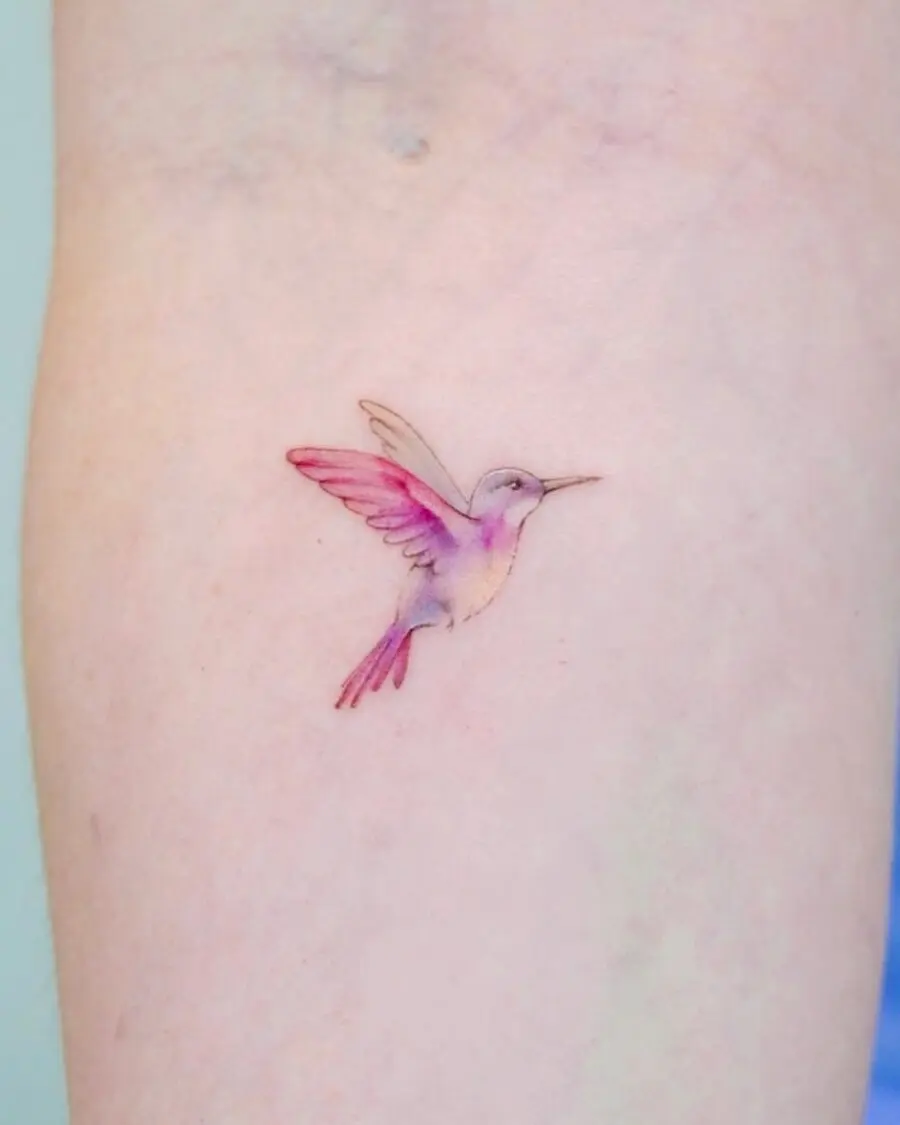 Delicate watercolor hummingbird tattoo on skin