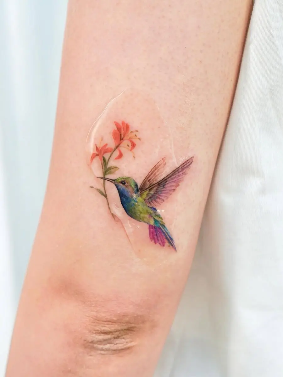 Vibrant hummingbird tattoo with floral design