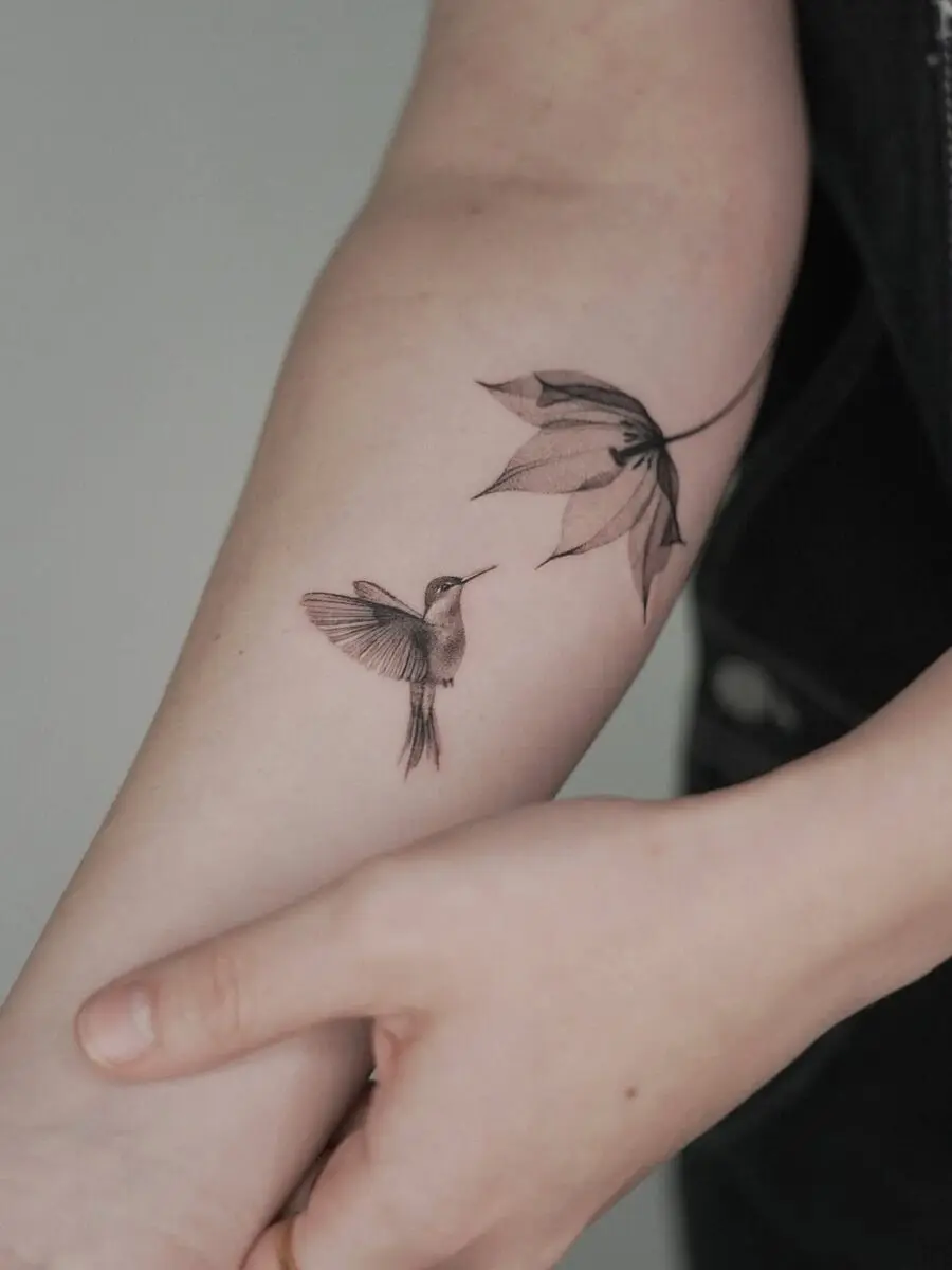 Graceful hummingbird and floral tattoo design
