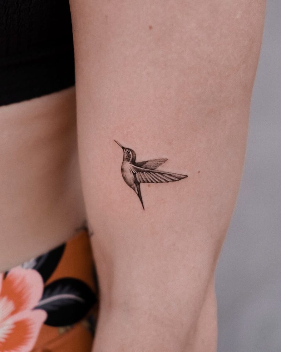 Elegant hummingbird tattoo design on a forearm