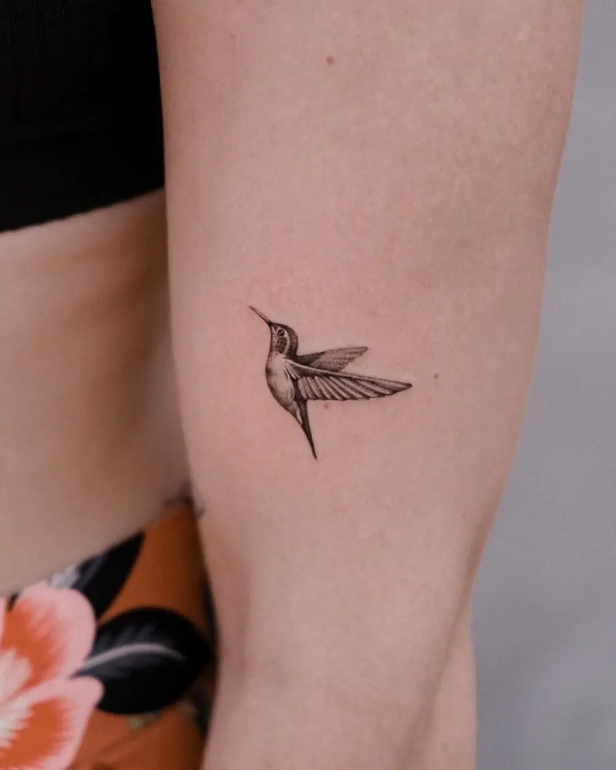 Elegant hummingbird tattoo design on a forearm