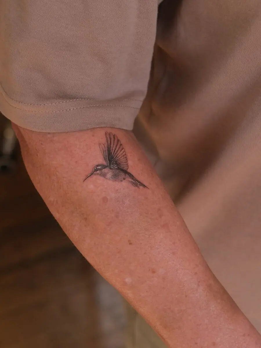 Elegant hummingbird tattoo on forearm