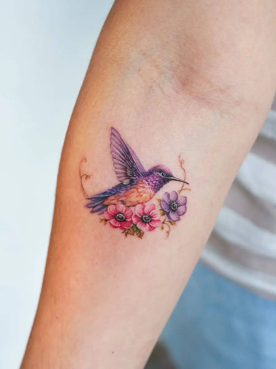 Elegant hummingbird tattoo with floral elements