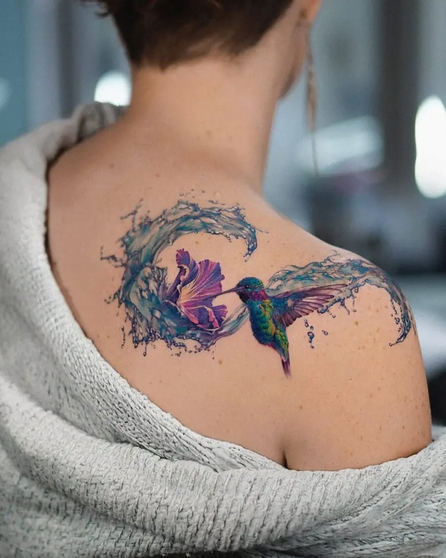 A vibrant hummingbird tattoo with floral elements