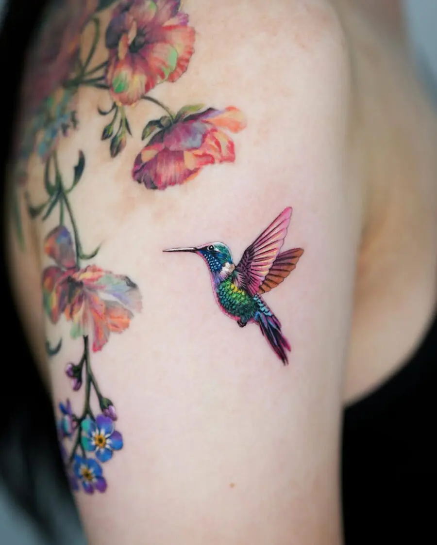 Colorful hummingbird tattoo with floral accent