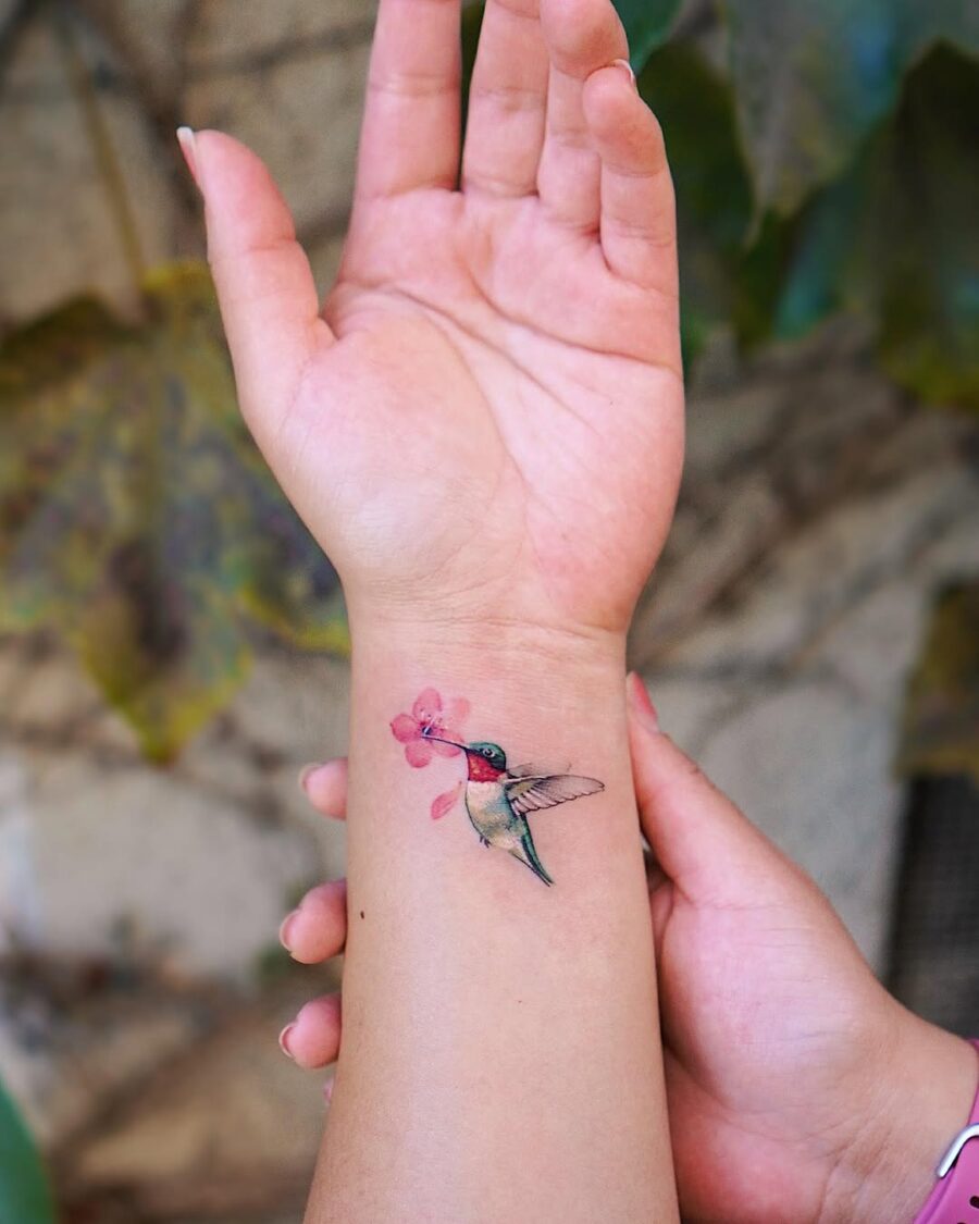 Elegant hummingbird tattoo with floral accent