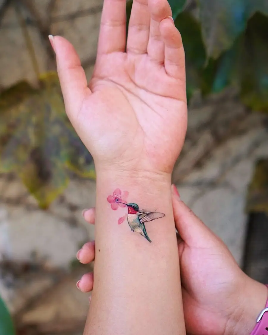 Elegant hummingbird tattoo with floral accent
