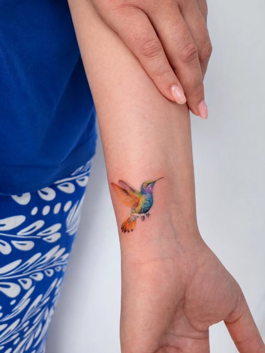 Colorful hummingbird tattoo on the wrist