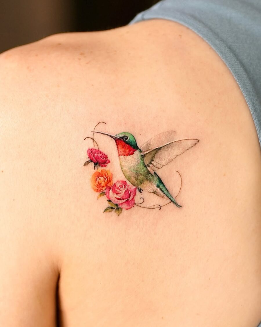Intricate hummingbird tattoo with blooming roses